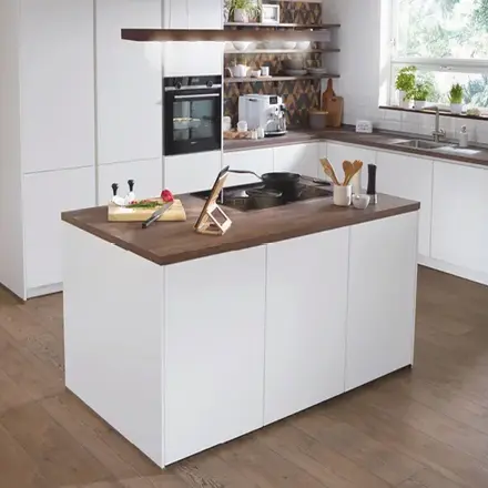 Weiße Küche mit Kochinsel, Holzarbeitsplatte, Spüle, Backofen und Fenster